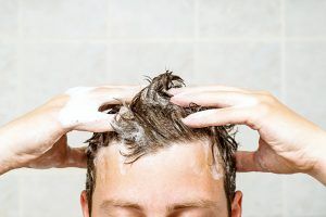man applying shampoo