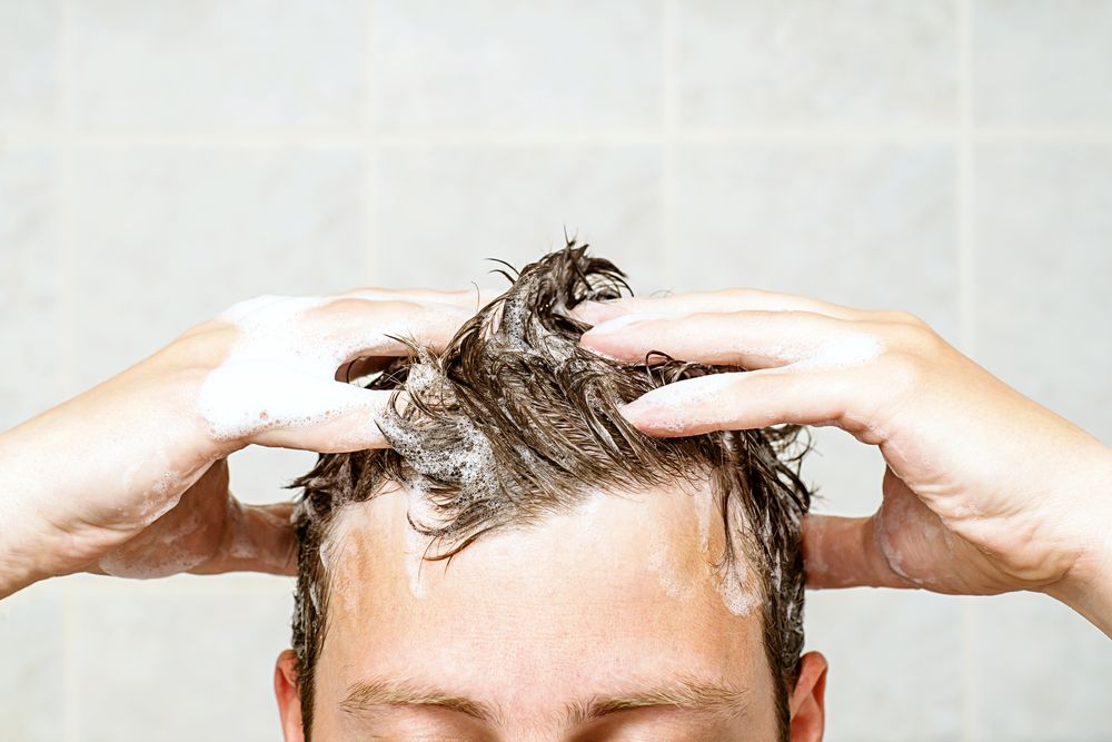 man applying shampoo