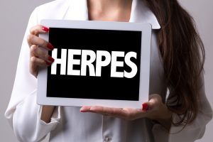 woman holding sign reading herpes
